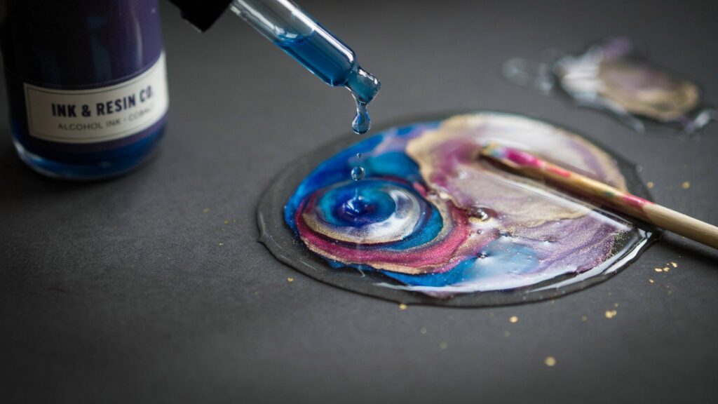 Alcohol ink dropped into UV resin creating colorful marbled swirls.